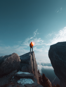 a person standing on a high, rock cliff peak